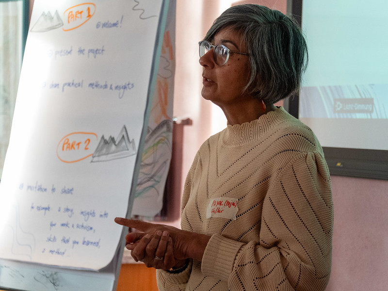 Eine Person steht neben einem Flipchart und trägt vor