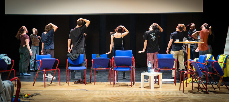 Menschen stehen nebeneinander und machen Dehnübungen